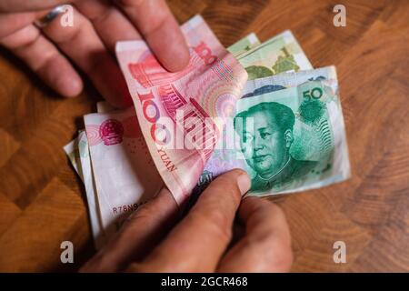 Männliche Hand zeigt Renminbi oder chinesischen Yuan oder abgekürzte RMB-Banknote, die offizielle Währung der Volksrepublik china. Auf der Vorderseite das Portr Stockfoto