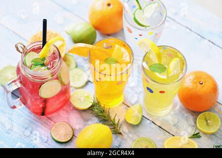 Exotische Sommergetränke erfrischende Auswahl an kalten Getränken Gläser frisches Obst und Gemüse auf Eis hausgemachter Cocktail-Tee mit Mojito Zitronenlime Orange ro Stockfoto