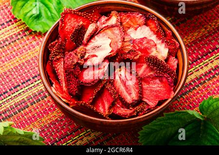 Sommerbeere, Fruchtdessert. Erdbeerchips, Beerensüße in Schüssel. Getrocknete Erdbeerscheiben Stockfoto