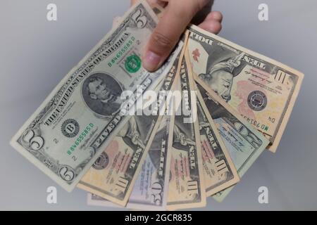 Eine Sammlung von US-Dollar in einer weiblichen Hand, etwas Taschengeld. Frau Hand zeigen US-Dollar-Banknoten. Mädchen halten Geld aus den USA. Weltcurr Stockfoto