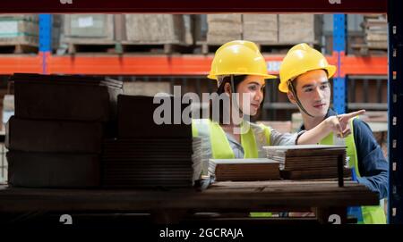 Lagerarbeiter, der Pakete in einem großen Lager überprüft Stockfoto