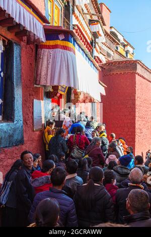 Shigatse, Tibet, China - 16. November 2019: Tibeter stehen an einem Schrein im Baiju-Tempel, dem Haupttempel des Tashilhunpo-Klosters Stockfoto