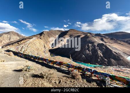 Kong mu Co See auf 5000 Meter über dem Meeresspiegel bei Tibet. Bunte Gebetsfahnen vor dem Wind winken. Türkisfarbenes Wasser im Bergsee. Neigen Stockfoto