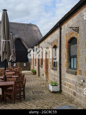 Eine alte Tythe-Scheune und ein angrenzender Stallblock, der in eine Bar, ein Café und ein Restaurant in Avebury, Wiltshire, Großbritannien, umgewandelt wurde Stockfoto