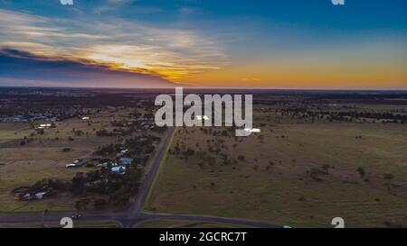 Luftaufnahme bei Sonnenaufgang über dem australischen Outback in der Nähe des Dorfes Roma, Queensland, Australien. Eine Drohnenansicht der aufgehenden Sonne über dem offenen f Stockfoto
