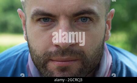 Der Blick eines weißen Mannes. Porträt, Nahaufnahme. Ein Mann mit einem Stoppeln im Gesicht. Stockfoto