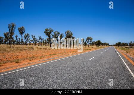 Der Weg ins nichts im australischen Outback. Der stuart Highway auf dem Weg zum Uluru oder Ayers Rock. Leere Straße durch die weite offene Wohnung austr Stockfoto