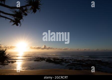 Sonnenaufgang am Strand des Dorfes Yeppoon, Queensland, Australien. Am Ufer des pazifischen Ozeans in der Nähe der Sunshine Coast. Die Sonne geht zwischen den C auf Stockfoto