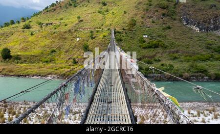 Die längste Hängebrücke im Himalaya in der Nähe der Stadt Punakha im Himalaya von Bhutan. Bekannt für die Punakha Dzong, eine Festung aus dem 17. Jahrhundert Stockfoto