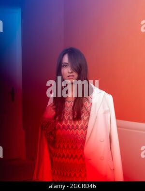 Porträt einer schönen kaukasischen dunkelhaarigen jungen Frau mit blauen und roten Glitts Stockfoto
