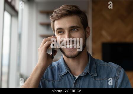 Glücklicher, positiver Tausendjähriger Mann, der anruft und am Handy spricht Stockfoto