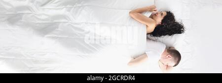 Traurige Männer und Frauen liegen mit dem Rücken zu jedem Andere Zimmer mit Blick von oben auf das Bett Stockfoto