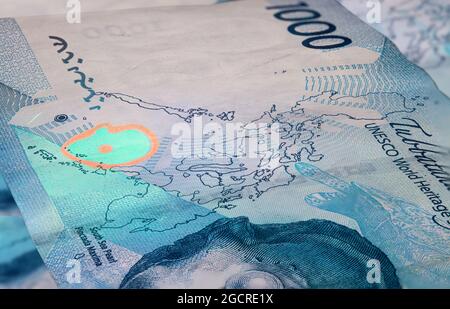 Das unsichtbare fluoreszierende Designelement auf der philippinischen Peso-Banknote 1000. Nahaufnahme einer 1000 Peso Banknote der Philippinen mit UV-Licht. Stockfoto