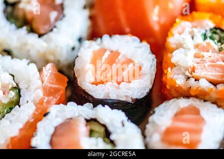 Verschiedene Sushi essen. Maki, Uramaki, Hosomaki, Sahimi und Nigiri Rollen in einem Teller, Nahaufnahme Zusammensetzung Stockfoto