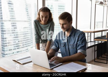 Freundliche Business Mentor Ausbildung Praktikant, Blick auf Laptop-Bildschirm Stockfoto