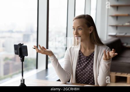 Selbstbewusster Online-Lehrer, der Webinar gibt und Unterricht auf dem Smartphone aufzeichnet Stockfoto