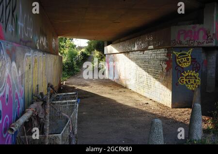 Blick durch eine Hauptstraßenunterführung mit Graffiti an den Wänden. Stockfoto