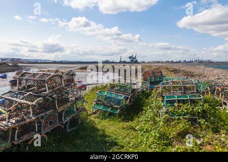 Ein Blick von Paddys Hole, Redcar, England, Großbritannien, zeigt die festgestemmten Boote und den industriellen Hintergrund von Teesport Stockfoto