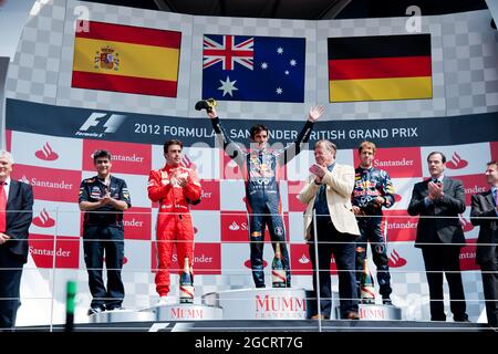 Das Podium (L bis R): Fernando Alonso (ESP) Ferrari, Zweiter; Mark Webber (AUS) Red Bull Racing, Rennsieger; Sebastian Vettel (GER) Red Bull Racing, Dritter.. Großer Preis von Großbritannien, Sonntag, 8. Juli 2012. Silverstone, England. Stockfoto