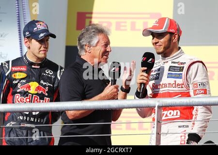 Mario Andretti (USA) mit Lewis Hamilton (GBR) McLaren und Sebastian Vettel (GER) Red Bull Racing auf dem Podium. Großer Preis der Vereinigten Staaten, Sonntag, 18. November 2012. Circuit of the Americas, Austin, Texas, USA. Stockfoto