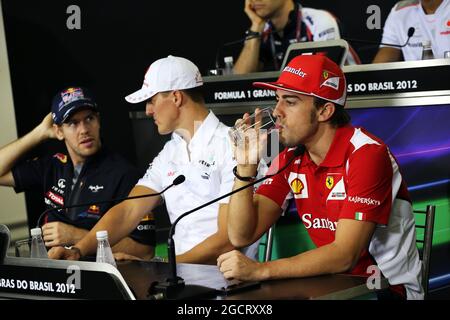 (L bis R): Sebastian Vettel (GER) Red Bull Racing und Michael Schumacher (GER) Mercedes AMG F1 mit Fernando Alonso (ESP) Ferrari bei der FIA-Pressekonferenz. Großer Preis von Brasilien, Donnerstag, 22. November 2012. Sao Paulo, Brasilien. Stockfoto
