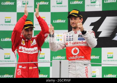 Rennsieger Jenson Button (GBR) McLaren feiert auf dem Podium mit dem zweitplatzierten Fernando Alonso (ESP) Ferrari. Großer Preis von Brasilien, Sonntag, 25. November 2012. Sao Paulo, Brasilien. Stockfoto