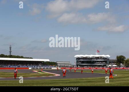 Marschalls kommen auf die Rennstrecke, um Trümmer von der Strecke zu entfernen. Großer Preis von Großbritannien, Sonntag, 30. Juni 2013. Silverstone, England. Stockfoto