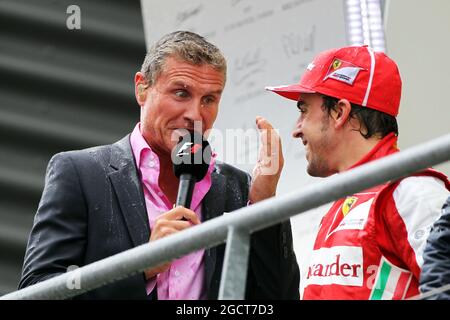 (L bis R): Ein nasser David Coulthard (GBR) Red Bull Racing und Scuderia Toro Berater / BBC Television Kommentator mit Fernando Alonso (ESP) Ferrari auf dem Podium. Großer Preis von Belgien, Sonntag, 25. August 2013. Spa-Francorchamps, Belgien. Stockfoto