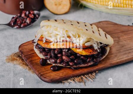 Typische venezolanische Arepa, hergestellt aus gebratenem Kochbananen, schwarzen Bohnen und Käse Stockfoto