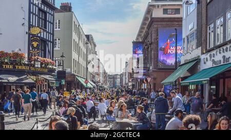 In der Old Compton Street, Soho, gibt es viele Restaurants und Cafés, die im Freien sitzen. London, Großbritannien. August 2021. Stockfoto