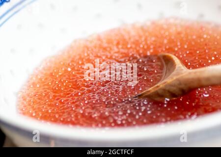 Eine Schüssel mit orangefarbenen, gekochten Tapiokakugeln. Tapioca-Kugeln wie diese werden oft in Bubble Tea verwendet. VEREINIGTES KÖNIGREICH Stockfoto