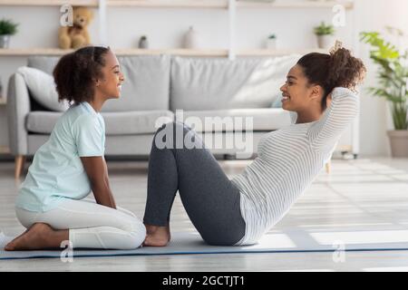 Fröhliche schwarze Mutter und Kind im Sportswear Training zusammen Stockfoto