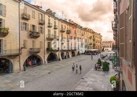 CUNEO, PIEMONT, ITALIEN - 2. AUGUST 2021: Via Roma bei Sonnenuntergang mit historischen bunten Gebäuden mit Arkaden (portici von Cuneo), Galimberti-Platz im Stockfoto