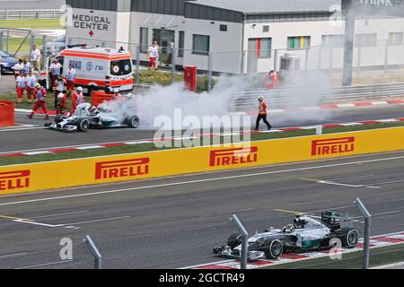 Nico Rosberg (GER) Mercedes AMG F1 W05 übergibt Teamkollege Lewis Hamilton (GBR) Mercedes AMG F1 W05, der nach einem Feuer im Qualifying auf der Boxengasse anhielt. Großer Preis von Ungarn, Samstag, 26. Juli 2014. Budapest, Ungarn. Stockfoto
