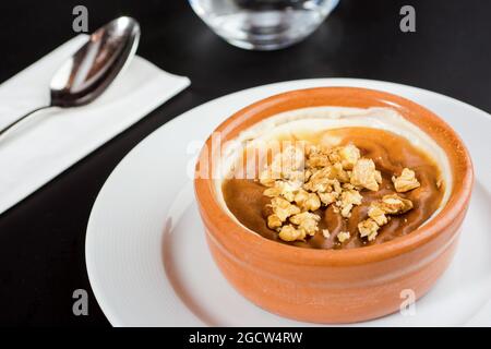 Türkischer Sutlac- oder Ofenreis-Pudding mit Haselnüssen in Tonschüssel. Stockfoto