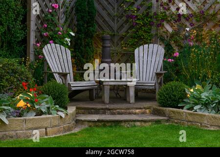 Schöner landschaftlich gestalteter privater Garten (modernes Design, gemischte Bepflanzung, Tisch, Sitze, Chiminea, Beleuchtete Globenleuchten) - Yorkshire, England, Großbritannien. Stockfoto
