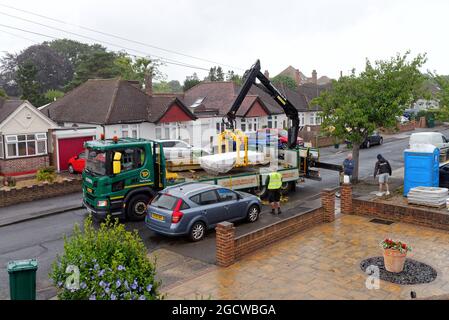 Ein Travis Perkins-Tieflader liefert Baumaterialien zu einem Vorstadthaus in Shepperton, Surrey, England Stockfoto