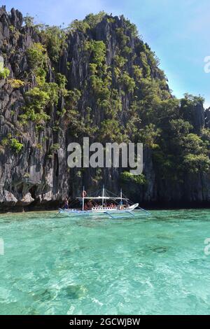 PALAWAN, PHILIPPINEN - 1. DEZEMBER 2017: Menschen fahren Outrigger bangka Boot auf Insel Hopping Tour in Palawan, Philippinen. 6 Millionen ausländische Touristen Stockfoto