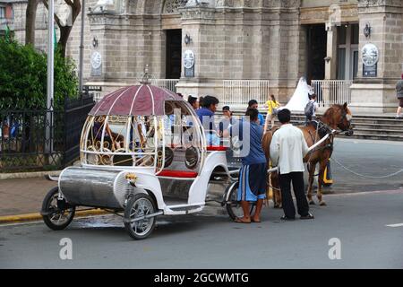 MANILA, PHILIPPINEN - 25. NOVEMBER 2017: Im Distrikt Intramuros, Manila, Philippinen, stehen Menschen mit der Pferdekutsche. Pferdetouren sind ein beliebter Tourist Stockfoto