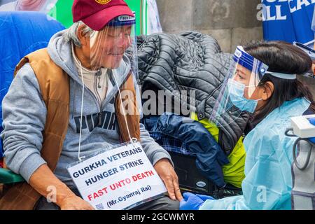 London, Großbritannien. 10th. August 2021. Krankenschwestern betreuen Herrn Gyanraj Rai, um während des Hungerstreiks sein medizinisches Wohlergehen zu gewährleisten. Britische Gurkha-Veteranen im Hungerstreik vor der Downing Street 10 fordern gleiche Rentenansprüche und Anerkennung von Boris Johnson in ihrem Dienst für Großbritannien. Stockfoto