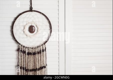 Traumfänger mit Jaspis-Nahaufnahme auf weißem Holzhintergrund im Schlafzimmer-Interieur Stockfoto