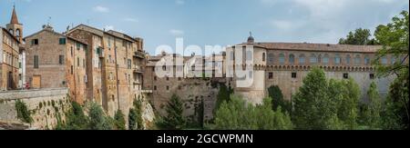 Häuser und der Herzogspalast von Urbania mit Blick auf den Fluss Metauro, die Provinz Pesaro und Urbino, Marken, Italien. Stockfoto