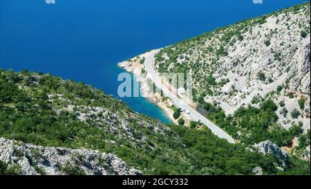 Luftaufnahme auf gebogener Straße entlang des mittelmeers - Velebit-Gebirge, Kroatien Stockfoto