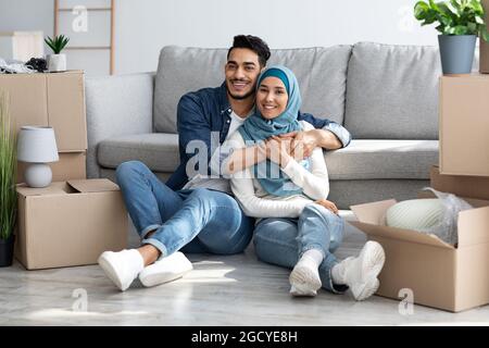 Schönes Paar aus dem Nahen Osten, das sich nach dem Umzug beim Auspacken ausruhte Stockfoto