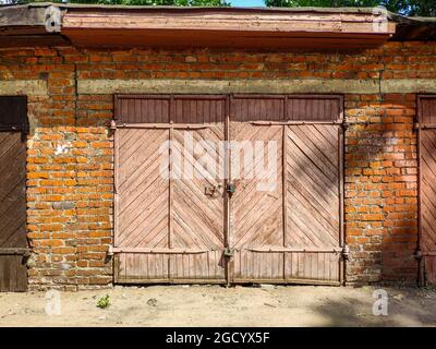 Rosafarbene Holztür zu einer alten Garage. Stockfoto