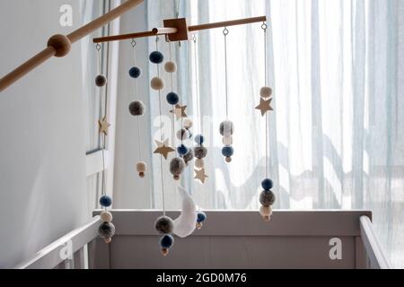 Babykrippe mobil mit Sternen, Planeten und Mond. Kinder handgemachtes Spielzeug über der neugeborenen Krippe. Erstes Baby Öko Spielzeug aus Filz und Holz hängend Stockfoto