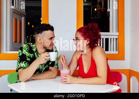 Fröhliches Paar mit Getränken im Café Stockfoto