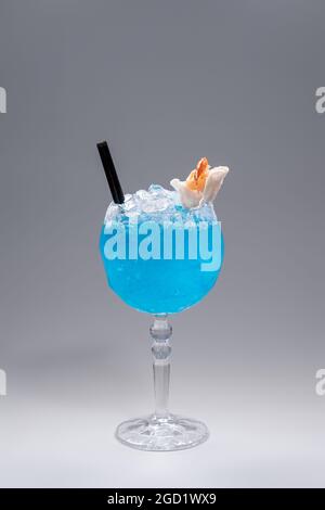 Luxuriöser blauer Alkoholcocktail mit Garnelen in Glas auf grauem Hintergrund Stockfoto