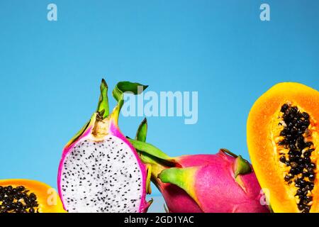 Zwei Hälften frische Bio-Drachenfrucht auf blauem Hintergrund, kreatives Sommer-Food-Konzept, Bannerhintergrund mit Kopierfläche, Minimalismus Trendy Food, Stockfoto