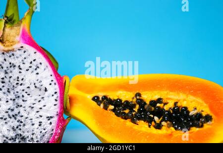 Zwei Hälften frische Bio-Drachenfrucht auf blauem Hintergrund, kreatives Sommer-Food-Konzept, Bannerhintergrund mit Kopierfläche, Minimalismus Trendy Food, Stockfoto